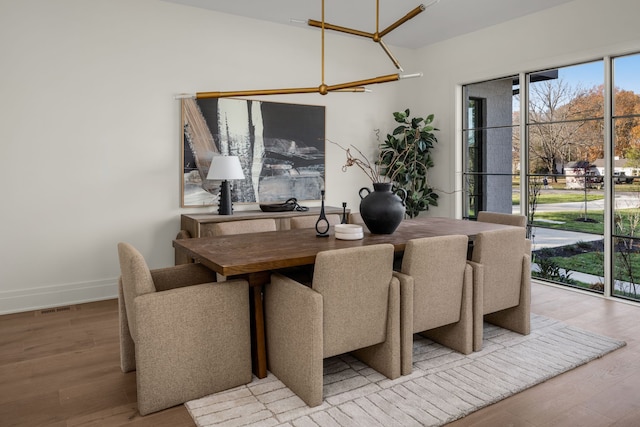 dining area featuring light hardwood / wood-style floors and an inviting chandelier