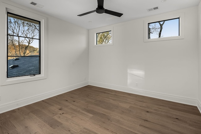 spare room featuring dark hardwood / wood-style flooring, a wealth of natural light, and ceiling fan