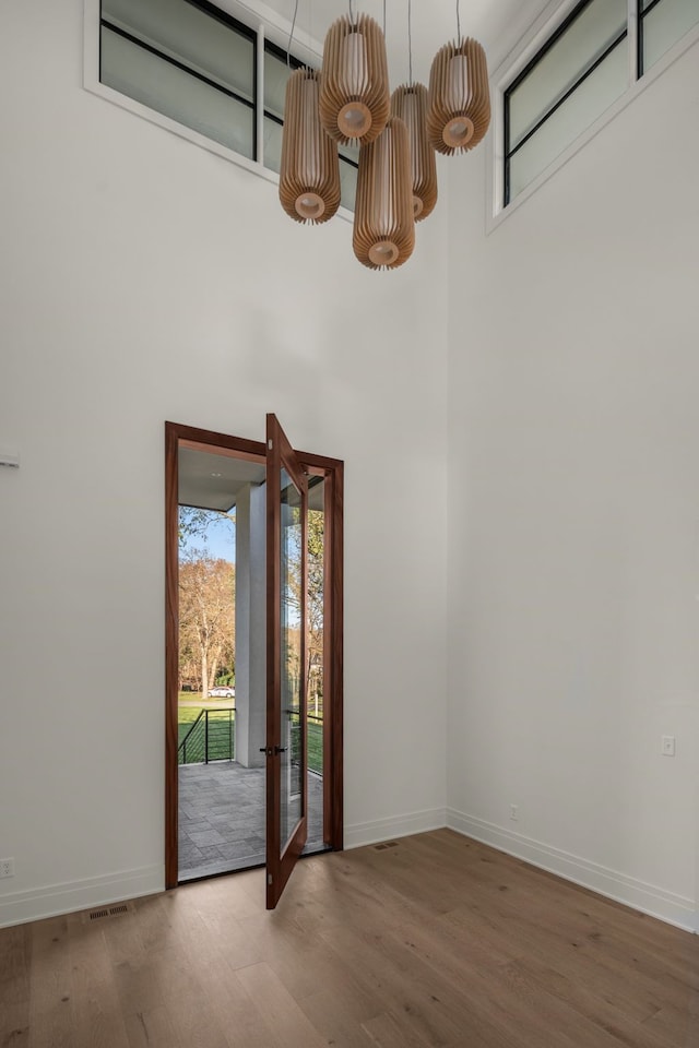 doorway with hardwood / wood-style floors and a high ceiling