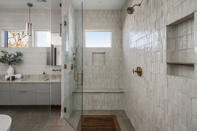 bathroom featuring tile patterned flooring, vanity, independent shower and bath, and tile walls