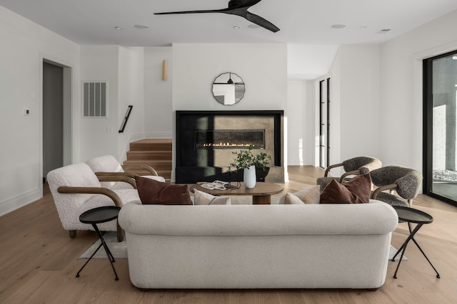 living room with light hardwood / wood-style flooring and ceiling fan