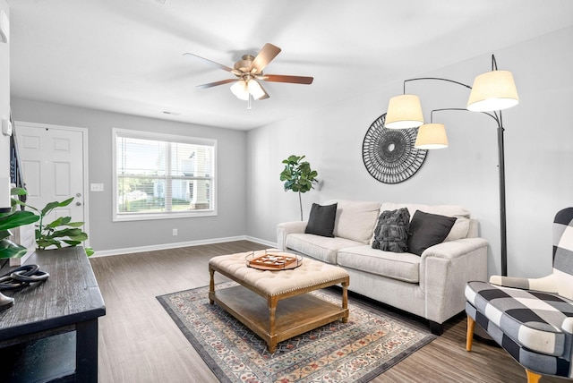 living room featuring ceiling fan and dark wood-type flooring