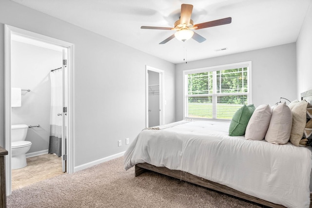 bedroom featuring ceiling fan, a walk in closet, a closet, and connected bathroom