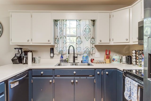 kitchen with blue cabinets, stainless steel appliances, white cabinetry, and sink