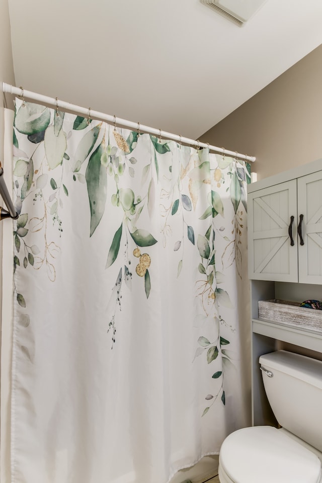 bathroom featuring a shower with shower curtain and toilet