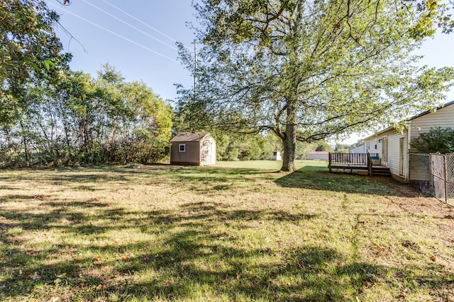 view of yard featuring a storage shed and a wooden deck