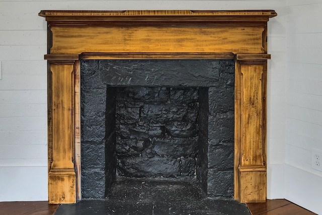 details with wood-type flooring and wooden walls