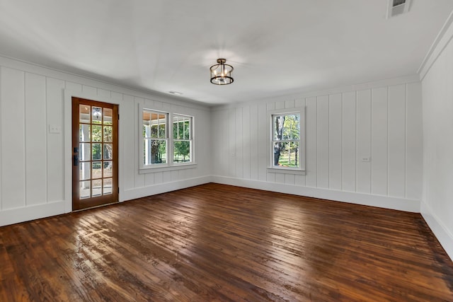 spare room featuring dark hardwood / wood-style floors and ornamental molding