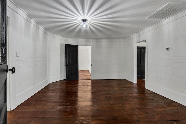 unfurnished room with dark hardwood / wood-style flooring and crown molding