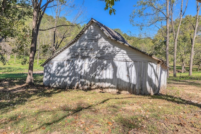 view of side of home with a lawn and an outdoor structure