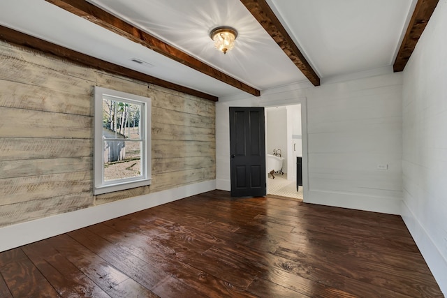 spare room featuring sink, dark wood-type flooring, and beamed ceiling