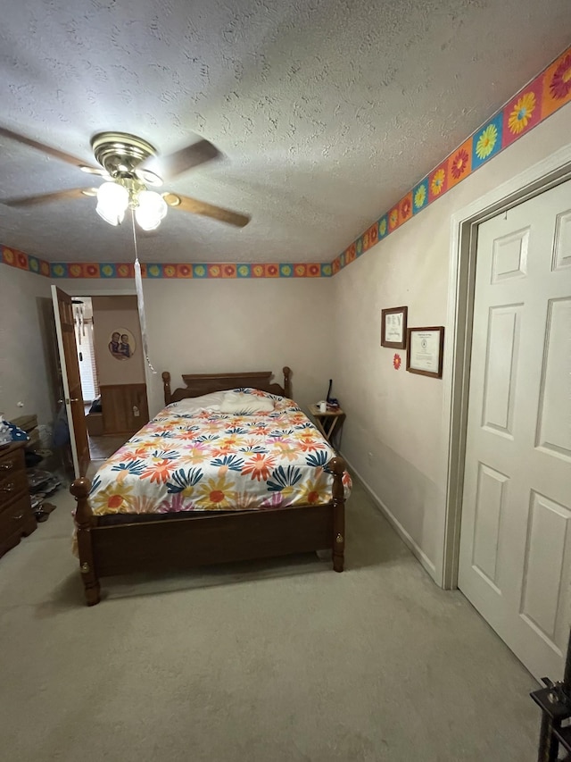 carpeted bedroom featuring a textured ceiling and ceiling fan