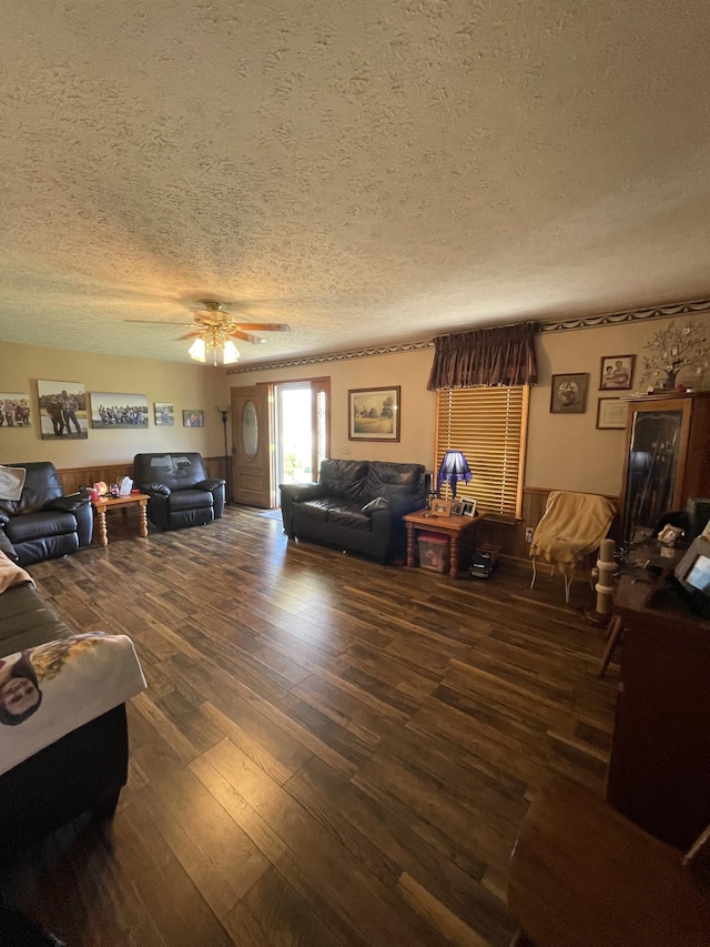 living area featuring wood-type flooring, a textured ceiling, and a ceiling fan