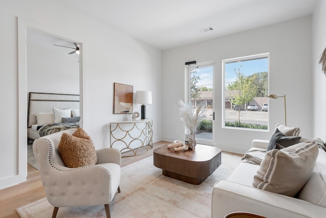 living room featuring light hardwood / wood-style flooring and ceiling fan