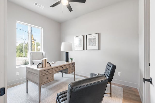 home office featuring a ceiling fan, baseboards, visible vents, and wood finished floors