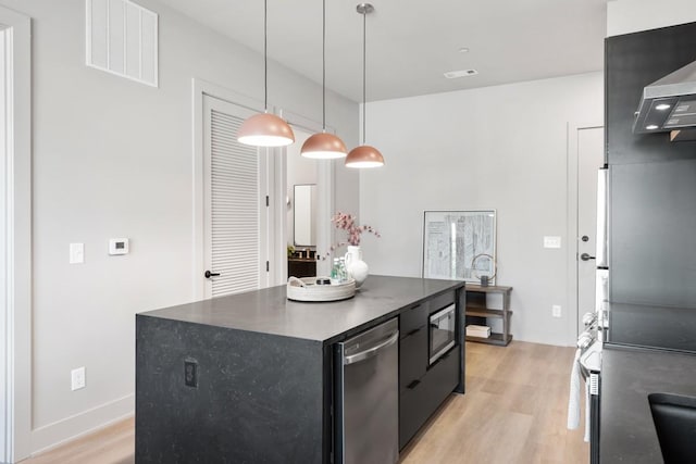 kitchen with visible vents, dark countertops, a kitchen island, dark cabinetry, and light wood-type flooring