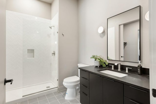 full bathroom with vanity, tiled shower, tile patterned flooring, and toilet