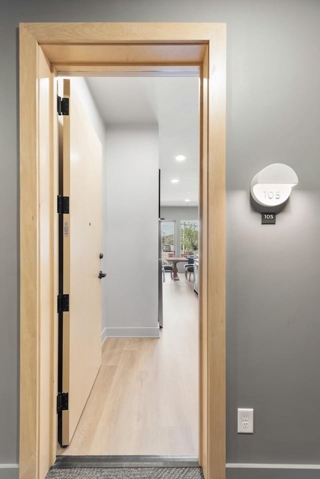 corridor featuring wood finished floors and baseboards