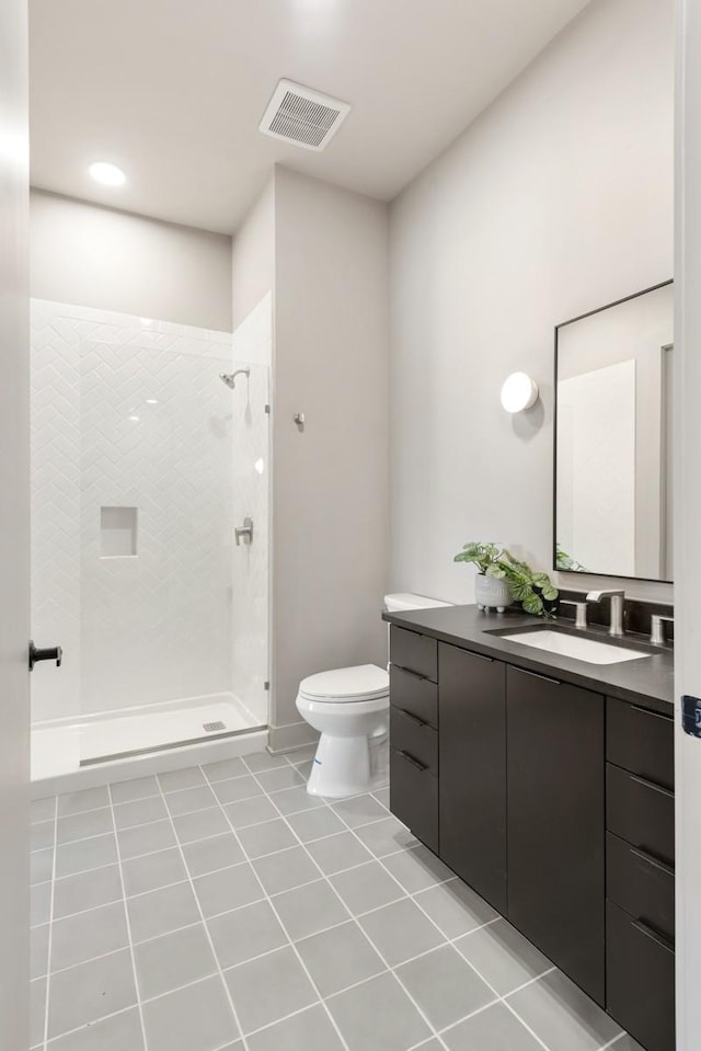 full bath featuring visible vents, tiled shower, toilet, tile patterned flooring, and vanity