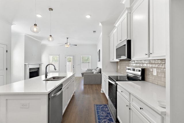 kitchen with a kitchen island with sink, sink, dark hardwood / wood-style flooring, white cabinetry, and appliances with stainless steel finishes