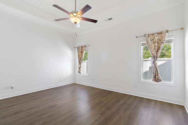 spare room with ceiling fan, dark wood-type flooring, and a wealth of natural light