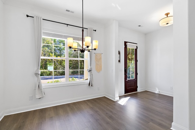 entrance foyer featuring an inviting chandelier, dark hardwood / wood-style flooring, and a wealth of natural light