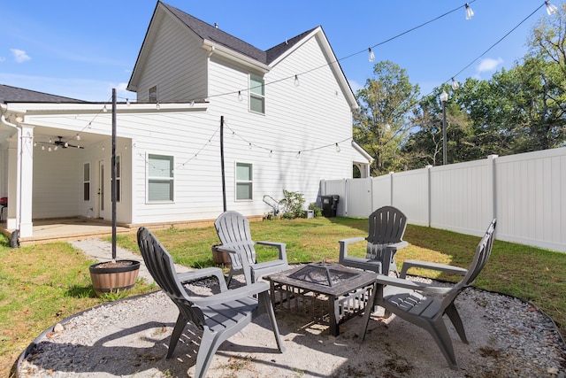 back of property with a patio, a fire pit, and a lawn