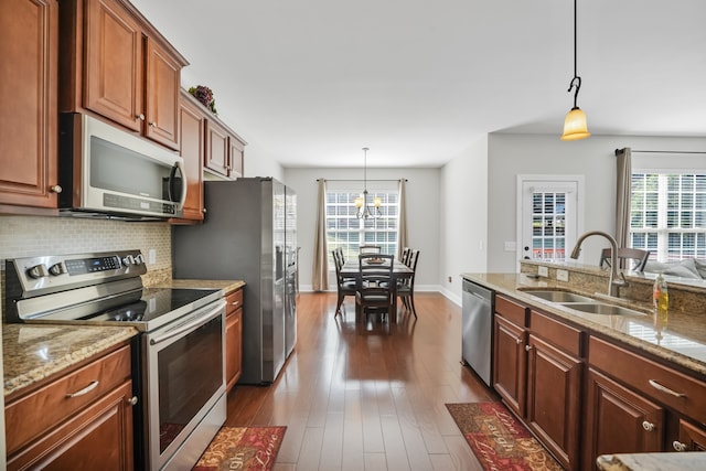 kitchen featuring appliances with stainless steel finishes, pendant lighting, a healthy amount of sunlight, and sink