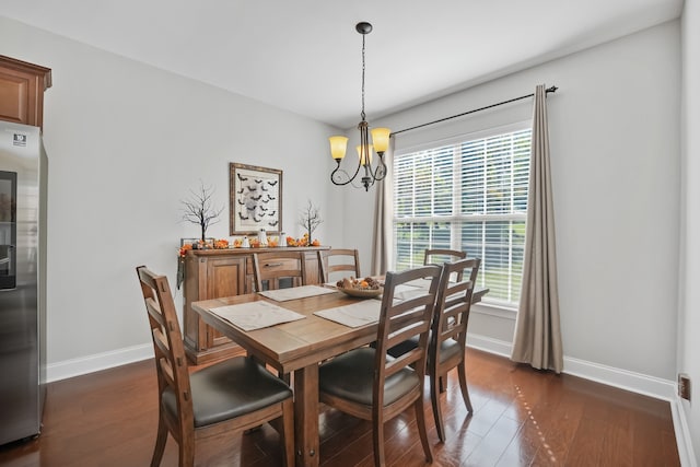 dining room with dark wood-type flooring and a chandelier