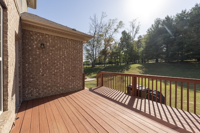 wooden deck featuring a lawn