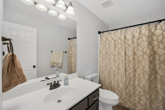 bathroom with curtained shower, vanity, and toilet