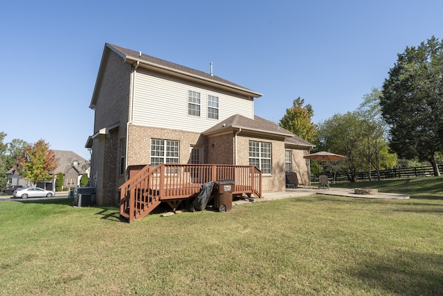 rear view of house featuring a yard, a wooden deck, and a patio