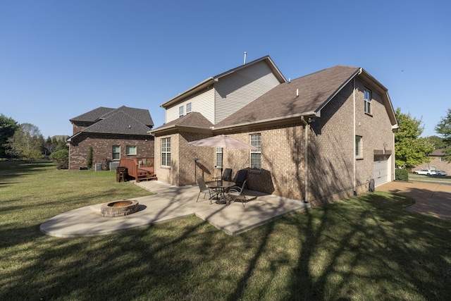 back of house featuring an outdoor fire pit, a patio area, and a lawn