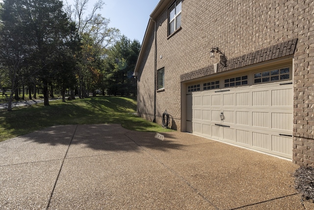 view of side of property featuring a lawn and a garage