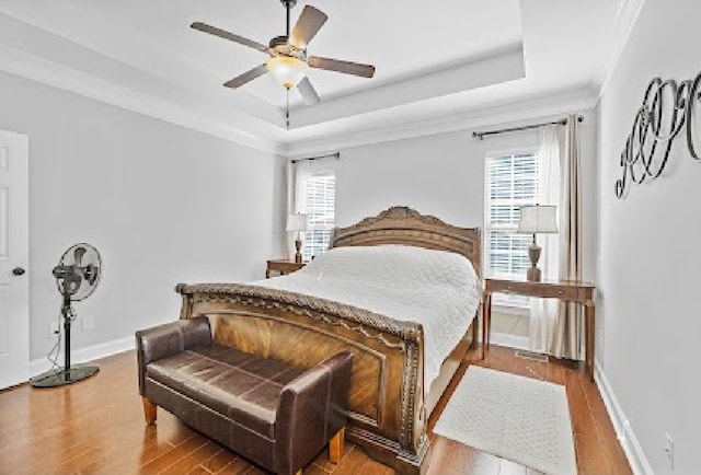 bedroom featuring ceiling fan, hardwood / wood-style floors, and multiple windows