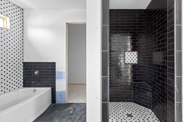 bathroom with a tub and tile walls