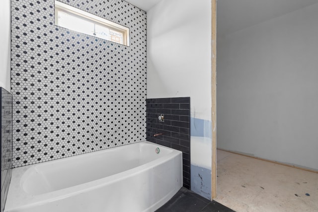 bathroom featuring a bathtub, tile patterned floors, and tile walls