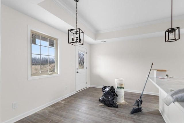 entryway with dark hardwood / wood-style flooring, ornamental molding, and a notable chandelier