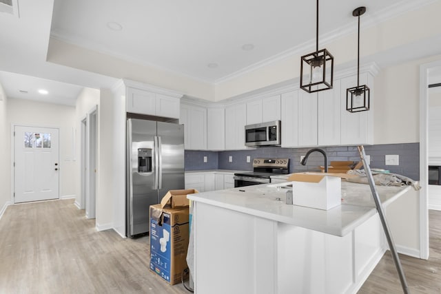 kitchen with kitchen peninsula, light wood-type flooring, stainless steel appliances, decorative light fixtures, and white cabinets