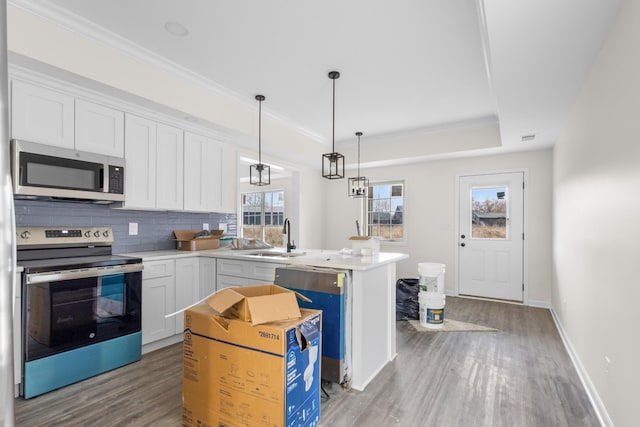 kitchen featuring white cabinetry, plenty of natural light, pendant lighting, and appliances with stainless steel finishes