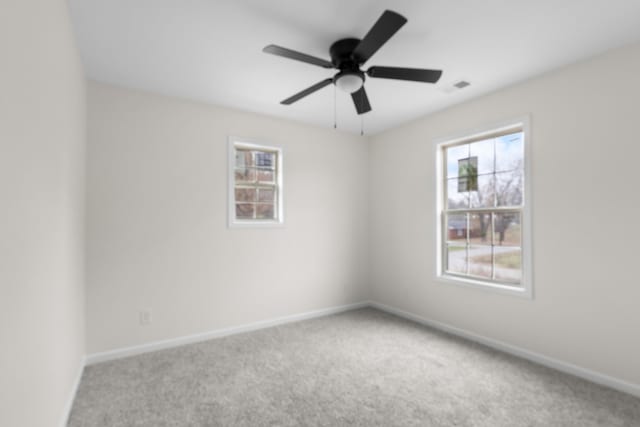 empty room with carpet flooring, ceiling fan, and plenty of natural light