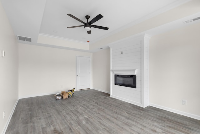 unfurnished living room featuring hardwood / wood-style floors, ceiling fan, ornamental molding, and a fireplace