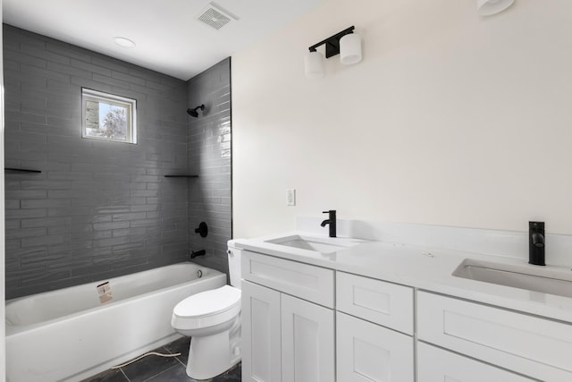 full bathroom featuring tile patterned flooring, vanity, toilet, and tiled shower / bath combo