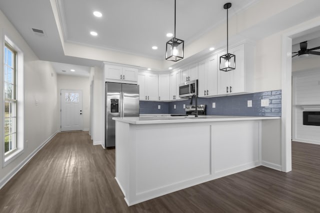 kitchen featuring dark wood-style flooring, a peninsula, visible vents, and appliances with stainless steel finishes