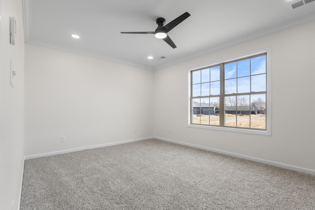 carpeted spare room with visible vents, baseboards, ceiling fan, and crown molding