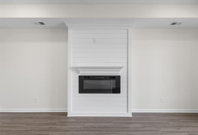 unfurnished living room featuring visible vents, baseboards, and dark wood-style flooring