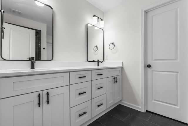 full bath with visible vents, a sink, tile patterned flooring, double vanity, and baseboards