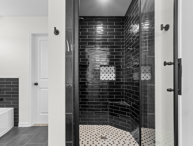 bathroom with tile patterned flooring, a shower stall, and a garden tub