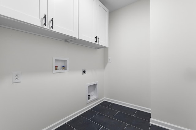 washroom with dark tile patterned flooring, cabinet space, baseboards, hookup for an electric dryer, and hookup for a washing machine