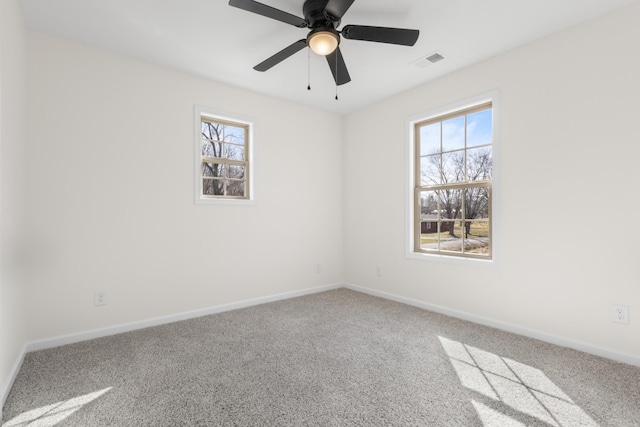 spare room featuring carpet flooring, baseboards, visible vents, and ceiling fan